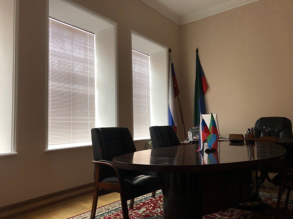 Горизонтальные жалюзи на высоких окнах кабинета руководителя