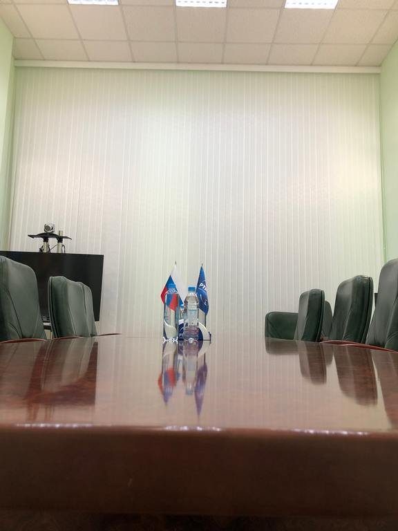Вертикальные жалюзи в переговорной государственного учреждения с флагами